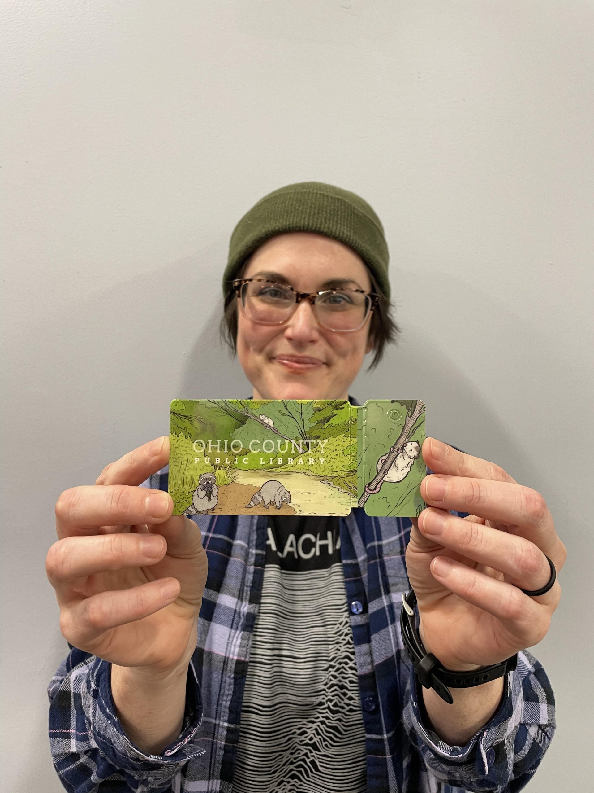 Natalie Kovacs with the card she designed for the Ohio County Public Library.