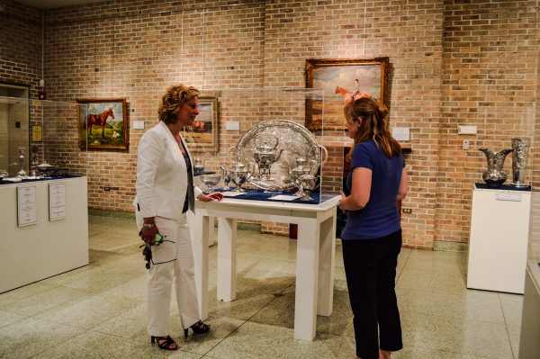 McCracken examines the Oglebay Family Silver Display with Kelsey Traeger, a curator at the Oglebay Mansion.