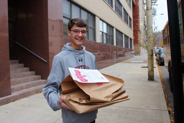 Student Thomas Minor was all smiles last Saturday as he assisted with the distribution of 6,000 grocery bags donated by Riesbeck's Food Markets.
