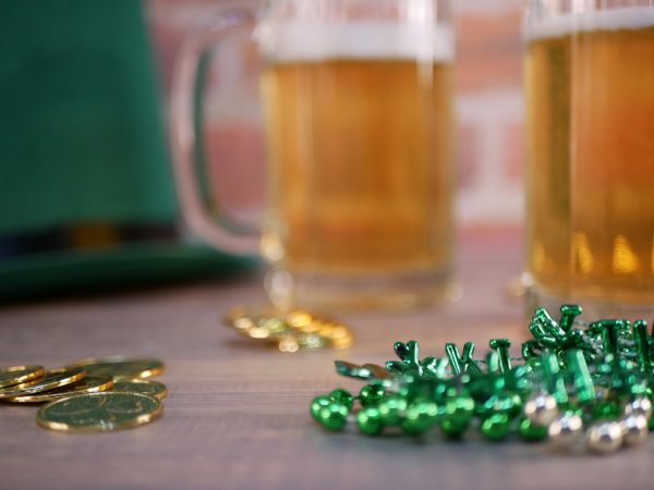 a table topped with two mugs of beer and gold coins st patricks day wheeling